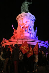 Low angle view of statue against illuminated building