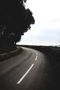 Road amidst trees against sky