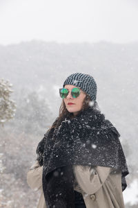 Woman wearing hat standing in snow