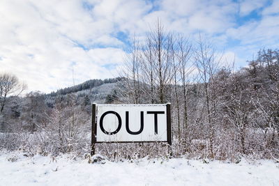 Information sign on snow covered field against sky