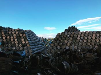 Stack of logs against blue sky