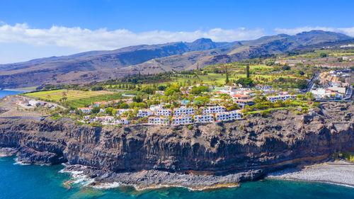 Panoramic view of sea and mountains against blue sky