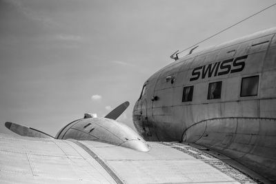 Airplane on airport runway against sky