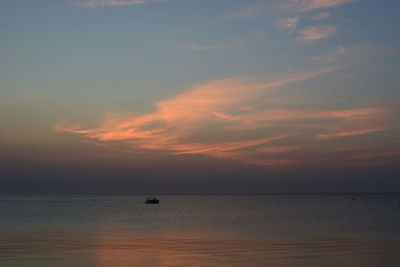 Silhouette boat sailing in sea against sky during sunset