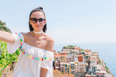Portrait of smiling man standing by sea against sky