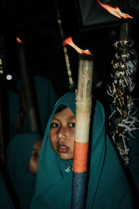 Portrait of girl with flaming torch at night