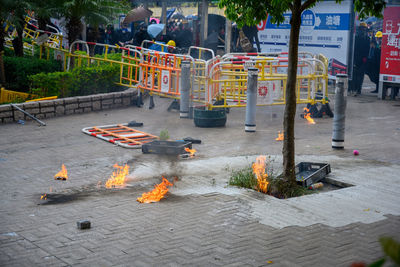 People on footpath by street in city