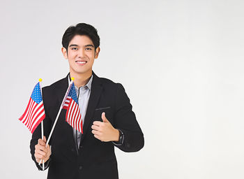 Portrait of smiling man standing against white background