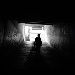 Rear view of silhouette man walking on staircase