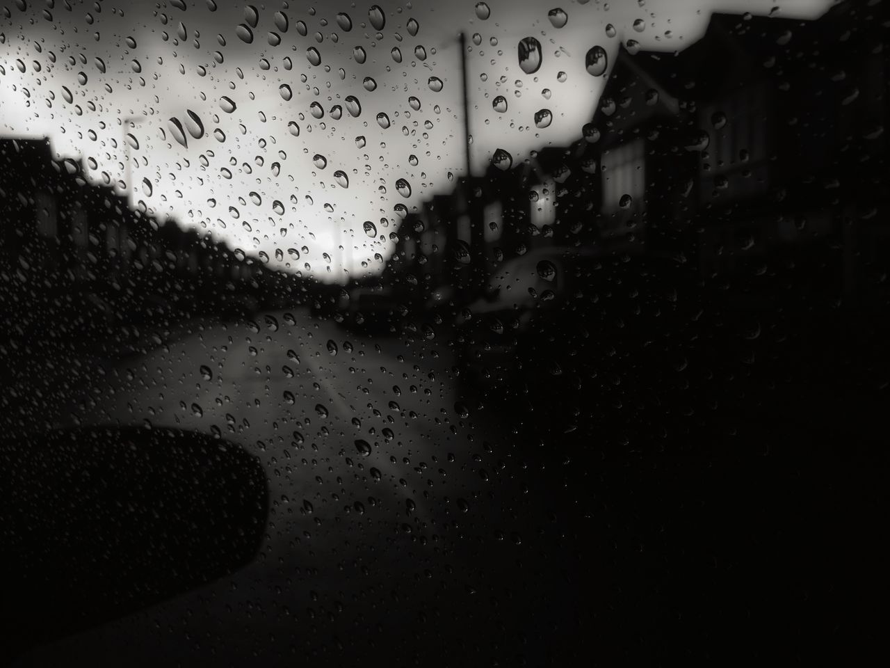 CLOSE-UP OF WATERDROPS ON GLASS AGAINST SILHOUETTE TREES