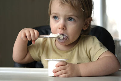 Portrait of cute boy eating food at home