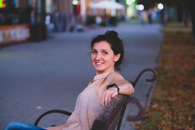 Portrait of a smiling young woman. elegant european woman sitting on bench.