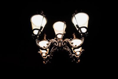 Low angle view of illuminated chandelier hanging in darkroom