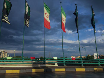 Multi colored flags against sky in city