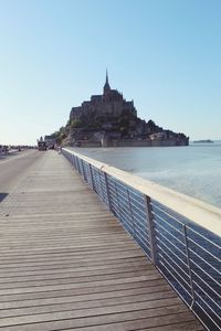 View of temple by sea against clear sky