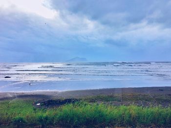 Scenic view of sea against cloudy sky