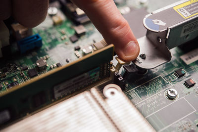 Cropped hand of person repairing circuit board