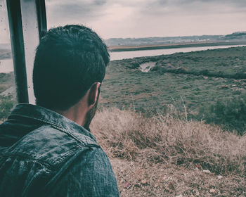 Man looking at landscape against sky