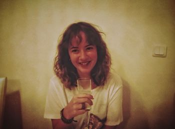 Portrait of a smiling young woman drinking glass