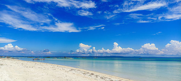 Scenic view of beach against blue sky