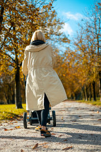 Rear view of woman walking on road