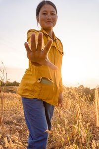 Mid adult man standing on field against sky