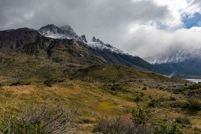 Scenic view of mountains against cloudy sky