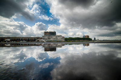 Reflection of building in lake against sky