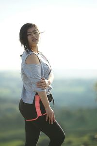 Young woman standing on mountain against clear sky