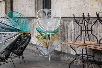 Empty chairs and tables against wall in city