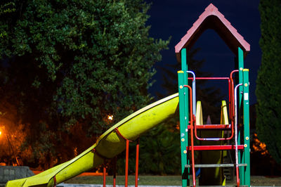 Train in playground against trees in park