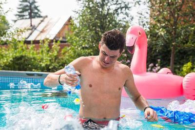 Full length of shirtless man in swimming pool