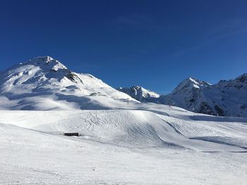 Scenic view of snowcapped mountains against clear blue sky