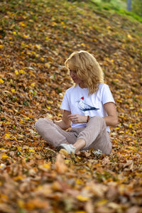 Side view of woman sitting on field