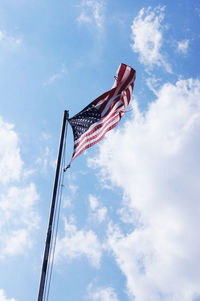 Low angle view of american flag against cloudy sky