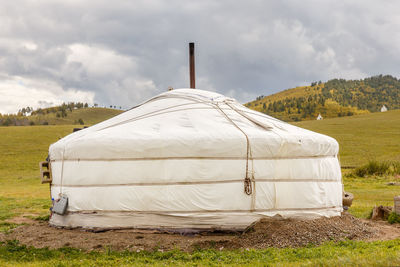 View of tent on field against cloudy sky