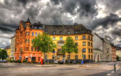 Buildings in city against cloudy sky