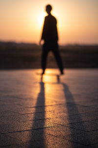 Silhouette man standing against sky during sunset