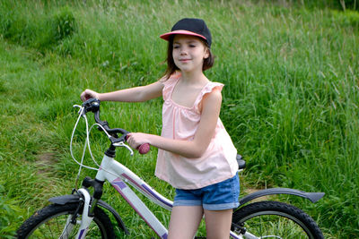 Portrait of boy riding bicycle on field