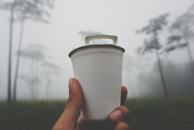 Close-up of hand holding drink against blurred background