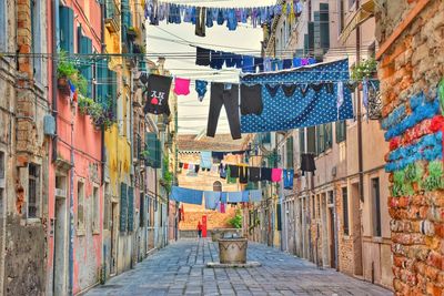 Clothes drying on alley amidst buildings in town