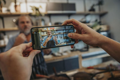 Cropped image of hand holding smart phone