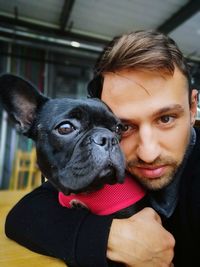 Close-up of portrait of man with dog at home 