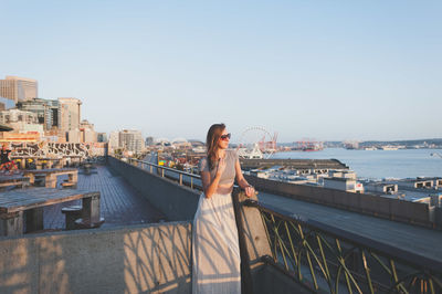 Young woman standing at building terrace in city