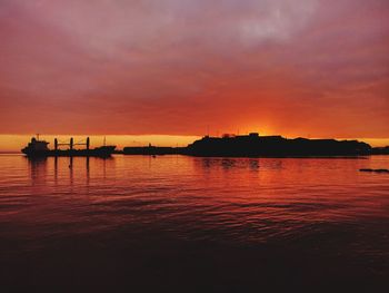 Scenic view of sea against dramatic sky during sunset