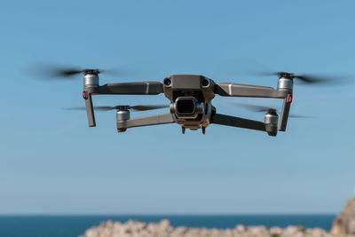 Drone flying against clear blue sky