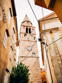 Low angle view of clock tower amidst buildings in city