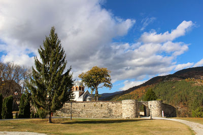 Built structure by trees against sky