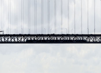 Low angle view of bridge against cloudy sky