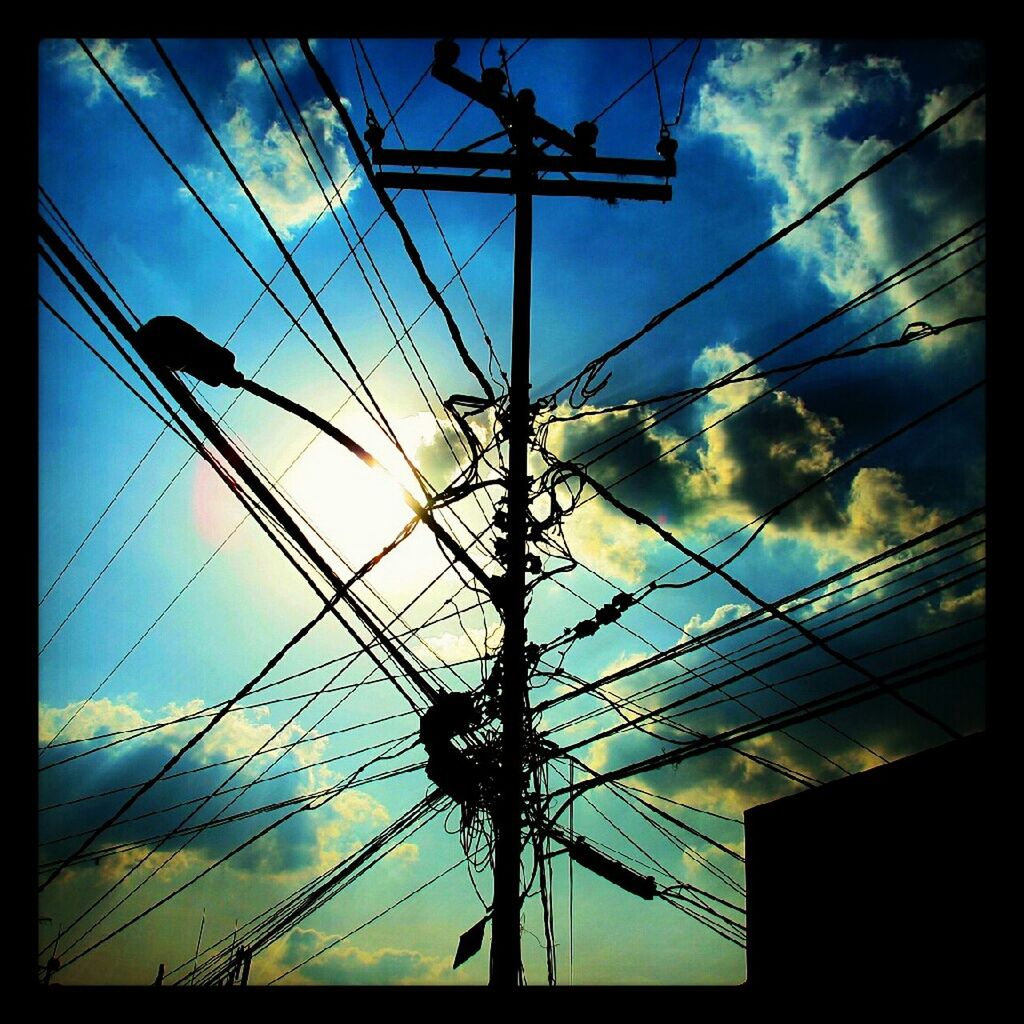 low angle view, power line, sky, power supply, electricity pylon, electricity, cable, cloud - sky, transfer print, connection, silhouette, auto post production filter, cloud, cloudy, fuel and power generation, technology, power cable, day, built structure, no people